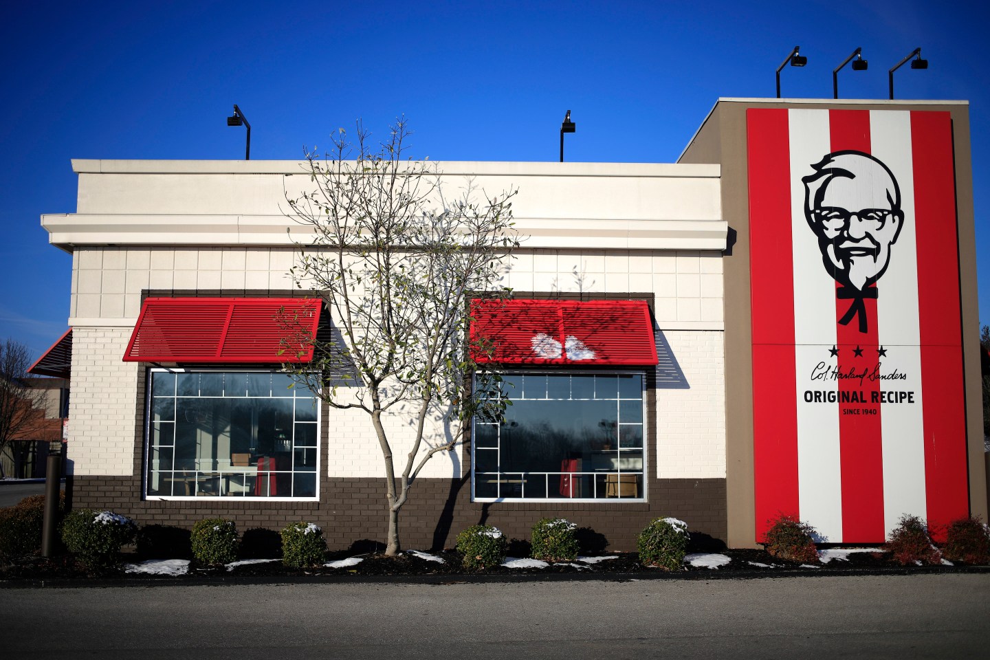 Eine moderne Fast-Food-Küche mit digitalen Bildschirmen und Personal, das Bestellungen zubereitet