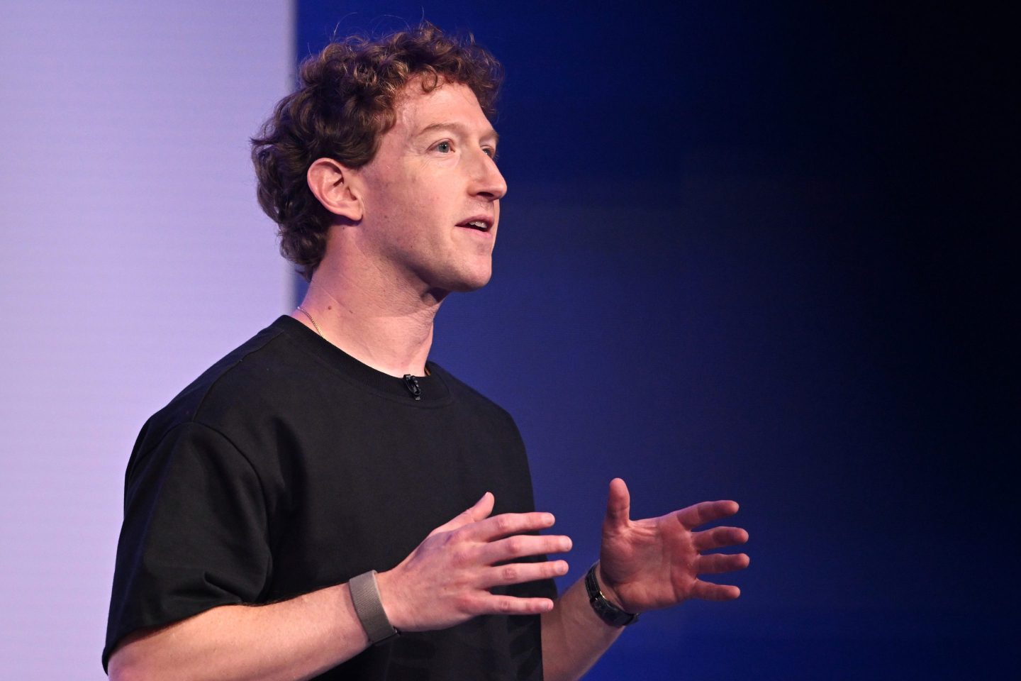 Mark Zuckerberg seated at a desk, reviewing a lengthy essay on artificial intelligence