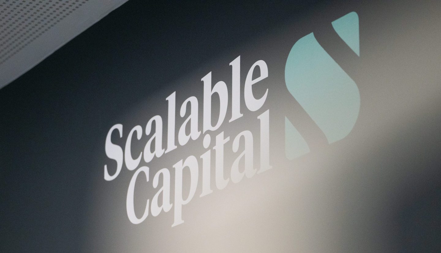 Scalable Capital Büro mit Symbolen, die KI-Assistenten wie ChatGPT und Claude darstellen