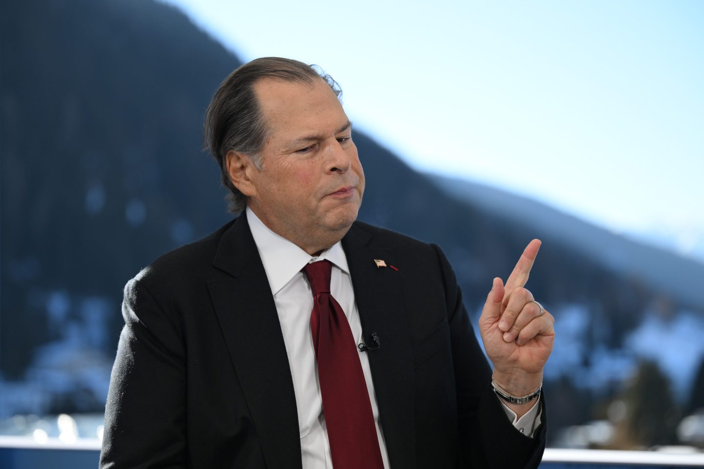 Marc Benioff spricht auf einer Salesforce-Konferenz, im Hintergrund KI-Grafiken
