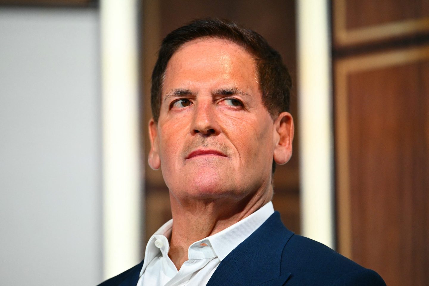 Mark Cuban spricht auf einer Konferenz, vor einer Kulisse der Skyline von Kalifornien