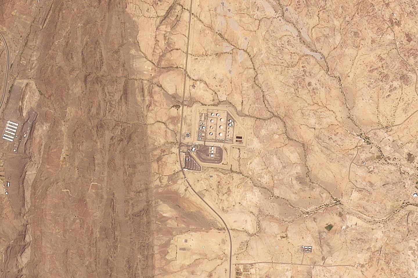 Barrel of oil against a backdrop of Middle Eastern oil facilities
