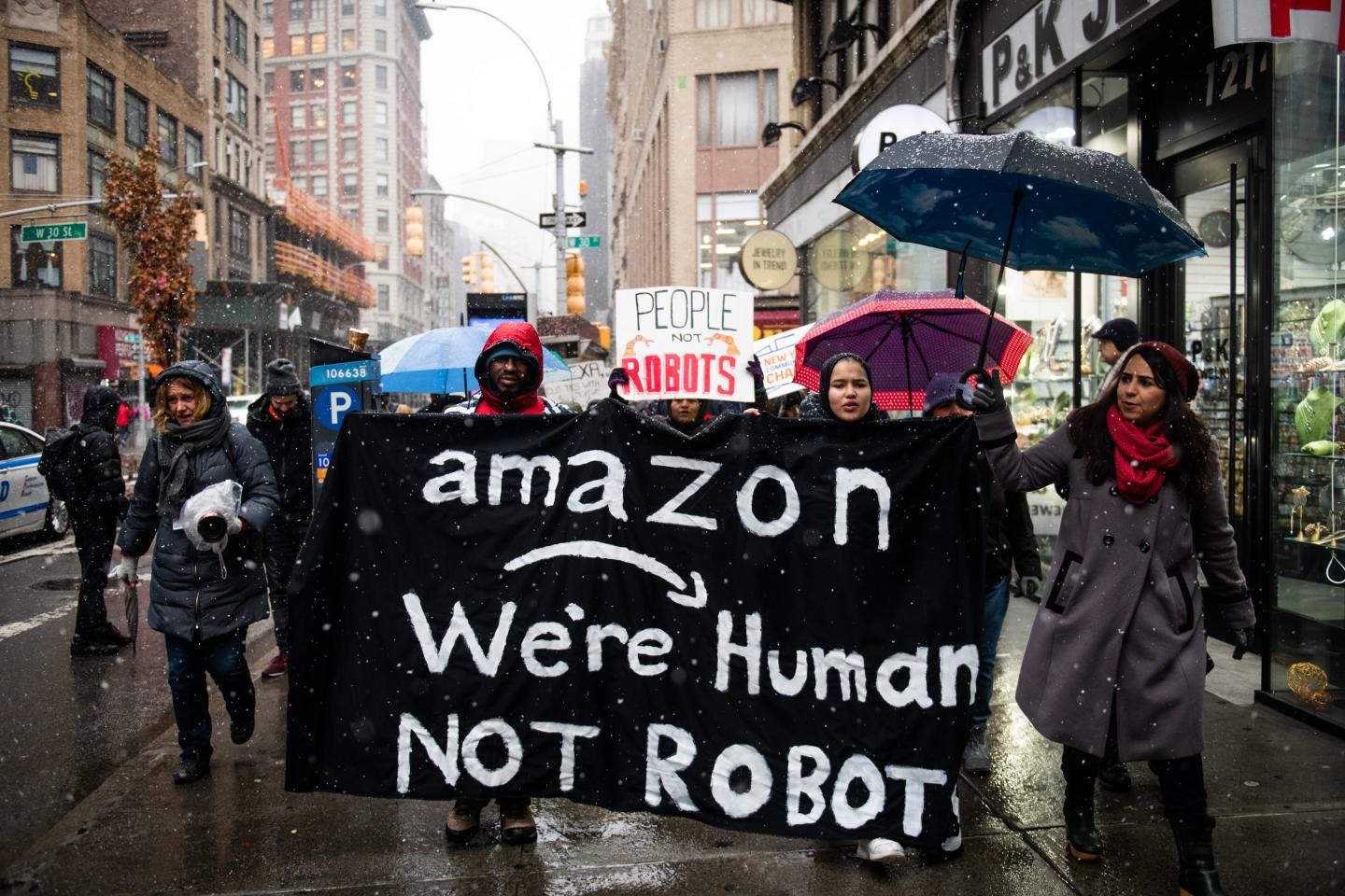 Amazon warehouse workers with a backdrop of corporate profit charts