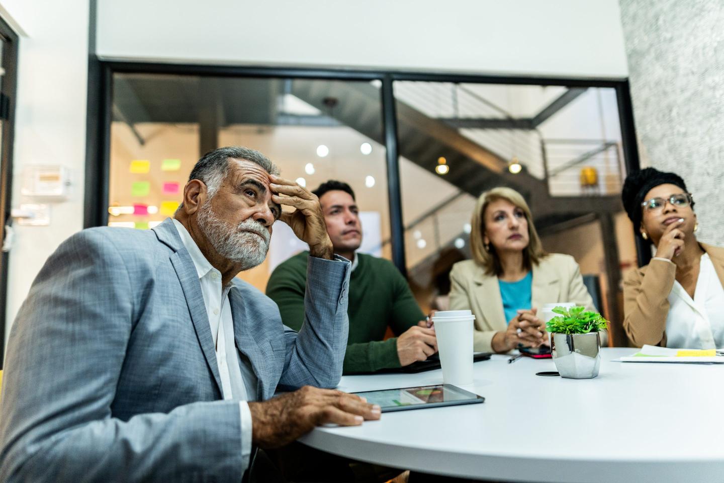 Office workers looking concerned while a digital AI interface glows on a screen