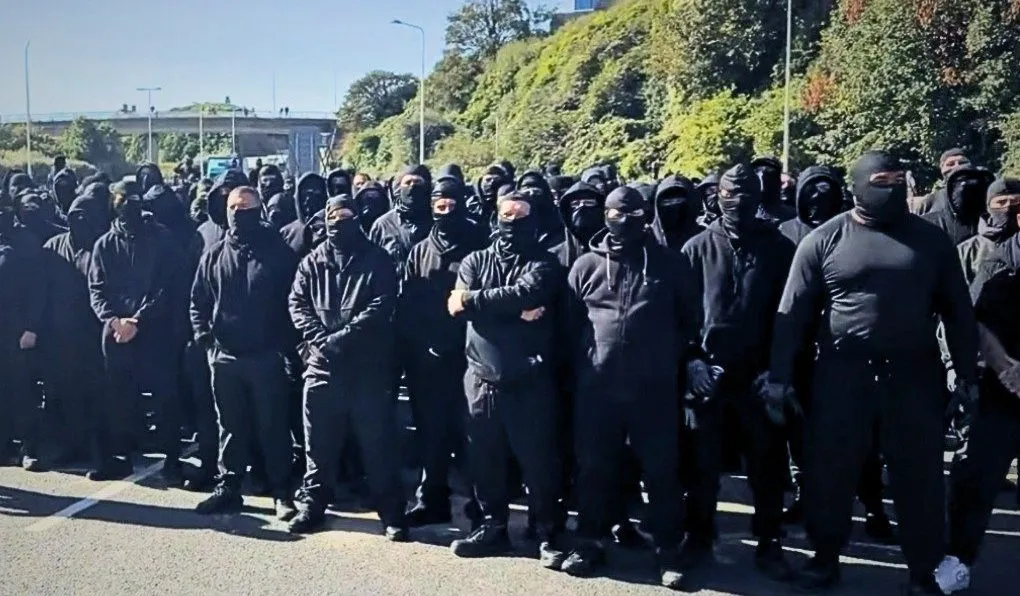 Maskierte Demonstranten marschieren in Dover während einer Anti-Migrationsdemonstration